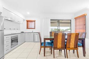 a kitchen with a dining room table and chairs at Bluewater Haven - Sweeping Lagoon Views with Pool in Trinity Beach