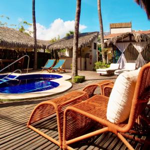 a wooden deck with chairs and a swimming pool at Pousada La Vie Jeri in Jericoacoara