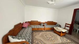 a bedroom with a large wooden bed and a rug at Marsa plage kelibia in Kelibia