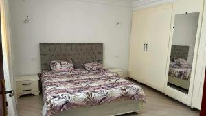 a bedroom with a large bed and a mirror at Marsa plage kelibia in Kelibia