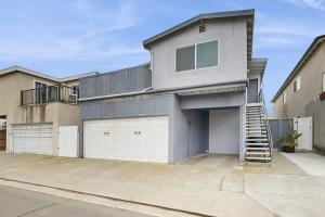 a house with two garage doors and a balcony at Upper Level Beach Retreat in Newport Beach