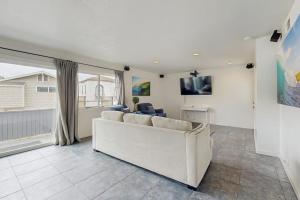 a living room with a white couch and a table at Upper Level Beach Retreat in Newport Beach