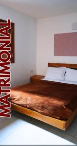 a bed with a wooden frame in a bedroom at Hotel Plazas Millas Merida in Mérida