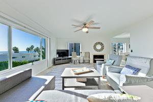 a living room with couches and a ceiling fan at Pier View Paradise in San Clemente