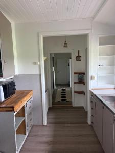 a kitchen with white cabinets and a hallway leading into a room at BAPA STAYs in Kristianstad +15 photos