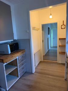 a kitchen with a microwave on a counter and a hallway at BAPA STAYs in Kristianstad