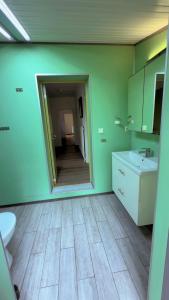 a bathroom with a mirror and a sink at BAPA STAYs in Kristianstad