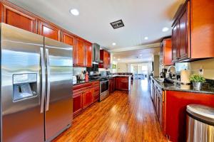 a kitchen with a stainless steel refrigerator and wooden cabinets at Dream Getaway in Anaheim