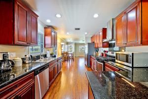 a large kitchen with wooden cabinets and black counter tops at Dream Getaway in Anaheim +30 photos