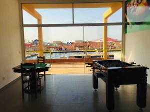 a room with a ping pong table and a large window at Catarina Condomínio Clube in Mairinque