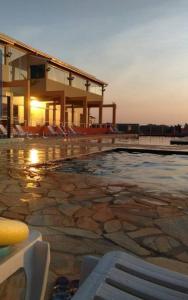 a swimming pool with chairs and a building at Catarina Condomínio Clube in Mairinque