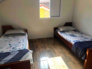 two twin beds in a room with a window at Catarina Condomínio Clube in Mairinque +37 photos