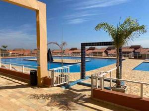 a resort with a pool and a palm tree at Catarina Condomínio Clube in Mairinque