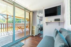 a living room with a couch and a flat screen tv at Fare AGT Moorea in Afareaitu