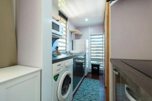 a kitchen with a washer and dryer in a room at Fare AGT Moorea in Afareaitu