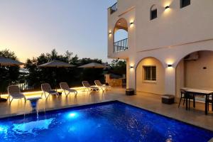 a villa with a swimming pool in front of a house at Abelia Hotel in Ksamil