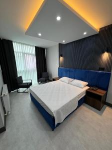a bedroom with a large bed with a blue headboard at Trio Palace in Istanbul