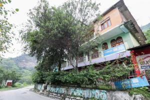 a building with graffiti on the side of a street at Hotel O Dp Bar in Rāmpur