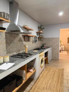 a kitchen with a sink and a stove top oven at Casa dos Andrés in Calheta