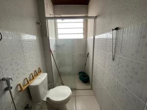 a white bathroom with a toilet and a shower at Flat Amarração Shopping in Luis Correia