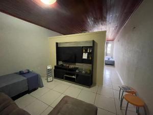 a living room with a large television and a couch at Flat Amarração Shopping in Luis Correia