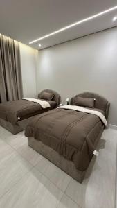 a bedroom with two beds and a wall at سويت بغرفة نوم شوحط in Abha