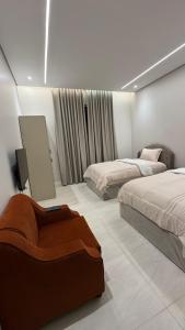 a bedroom with two beds and a painting on the wall at سويت بغرفة نوم شوحط in Abha