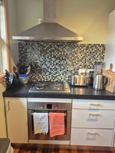 a kitchen with a stove with towels on the oven at Te Moana Delight in Waikanae