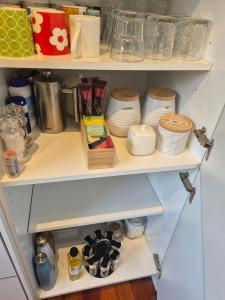 a shelf with dishes and other items on it at Te Moana Delight in Waikanae