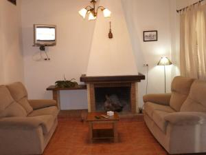 a living room with two couches and a fireplace at Apartahotel 4 vientos in Prado del Rey