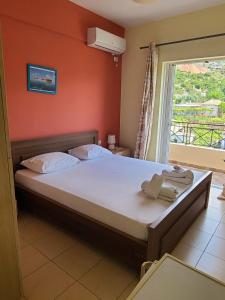 a bedroom with a large bed with a window at Marina Apartaments in Himare