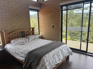 a bedroom with a bed and a large window at Casa - Finca Villa Violeta in San Vicente +78 photos