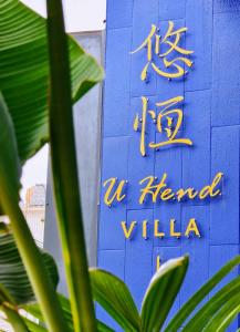 a sign for a hotel in front of a blue wall at u hend villa in Hengchun South Gate