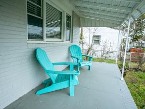 two blue chairs sitting on the side of a house at Coastal Home at Edgewater in Pleasantville