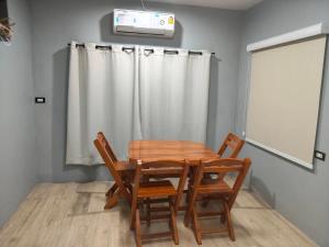 a dining room with a wooden table and chairs at Small home in Ban Khlong Hok Wa +11 photos