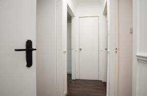 a hallway with white walls and a cross on the wall at BrightCentral Apartment With Parking in Glasgow