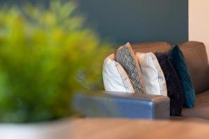 a brown couch with pillows on top of it at BrightCentral Apartment With Parking in Glasgow