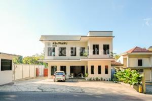 a building with a car parked in front of it at As Waru Hotel RedPartner in Palang-Putih