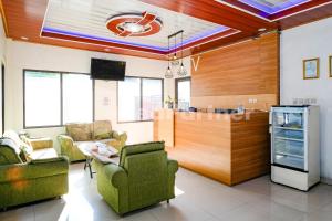 a living room with chairs and a counter in a room at As Waru Hotel RedPartner in Palang-Putih