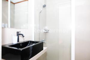a bathroom with a black sink and a shower at As Waru Hotel RedPartner in Palang-Putih +25 photos