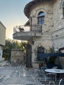 a building with a balcony and tables and chairs at Stone House in Vlorë