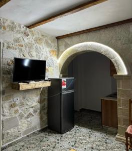 a stone kitchen with a refrigerator and a tv at Stone House in Vlorë +12 photos