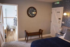 a bedroom with a clock on the wall and a toilet at The Coachmakers Arms in Wallingford