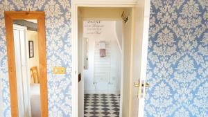 a hallway with blue and white wallpaper and a door at The Coachmakers Arms in Wallingford +2 photos