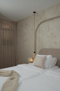 a bedroom with a large bed with white sheets and pillows at פנינת חמד Pninat Chemed in Safed +8 photos
