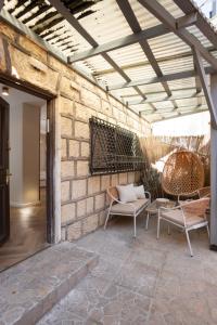 an outdoor patio with chairs and a brick wall at פנינת חמד Pninat Chemed in Safed