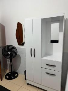 a white cabinet with a fan and a chair at Refúgio Beira Mar Na Praia da Tartaruga in Rio das Ostras +17 photos
