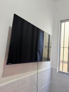 a flat screen tv hanging on a wall at Refúgio Beira Mar Na Praia da Tartaruga in Rio das Ostras