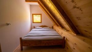 a bed in a small room with a wooden ceiling at Melaya 1600 in Kolašin