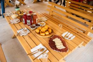 a long wooden table with food and drinks on it at Melaya 1600 in Kolašin